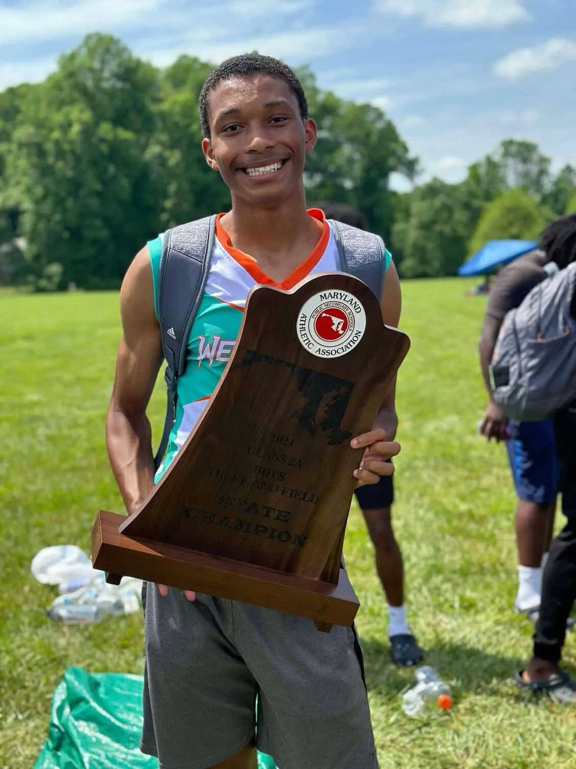 Christian Wilbon smiling holding award state trophy on field